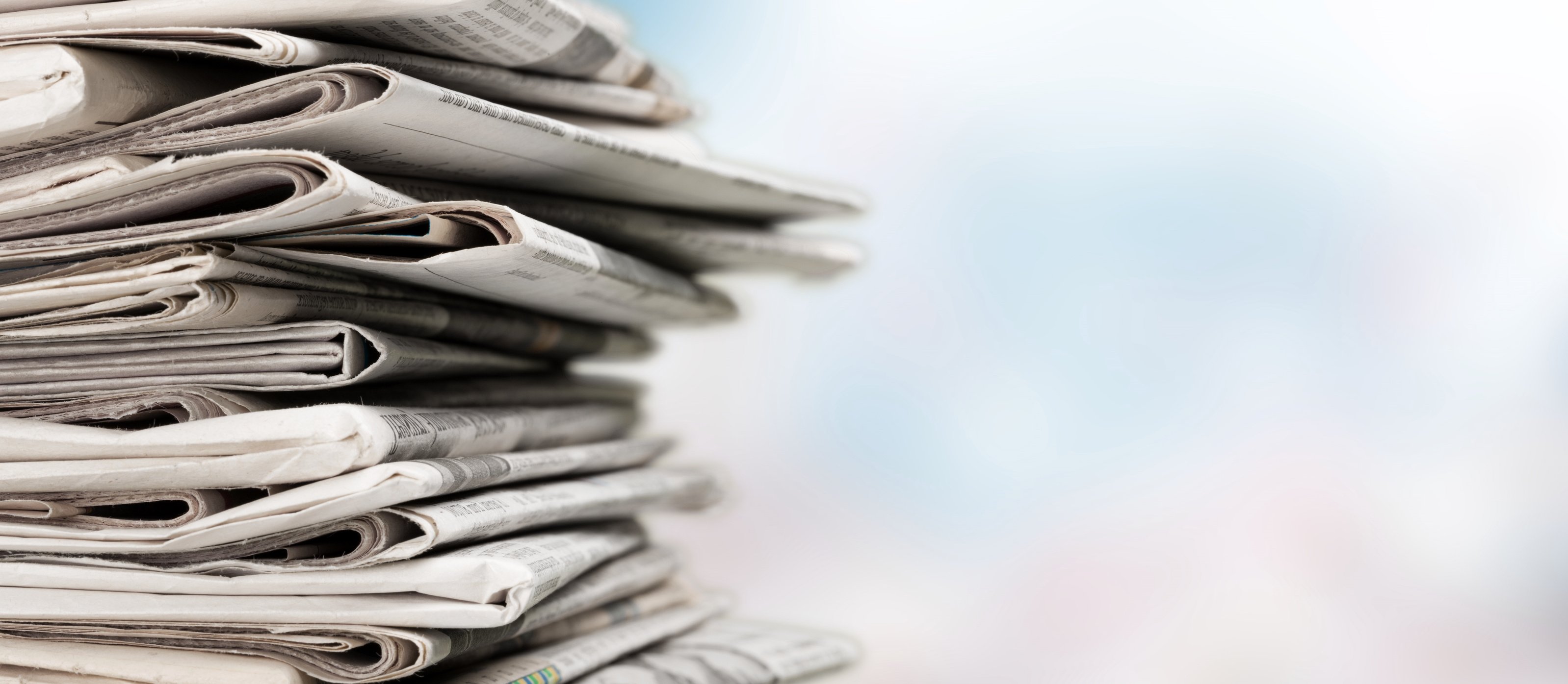 Pile of Printed Newspapers on Background